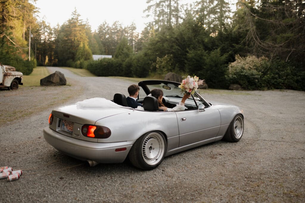 Hayley Zumkeller photography and videography team from Victoria BC capture a groom and bride with their dogs inside a vintage care just following their Nanaimo outdoor wedding ceremony.