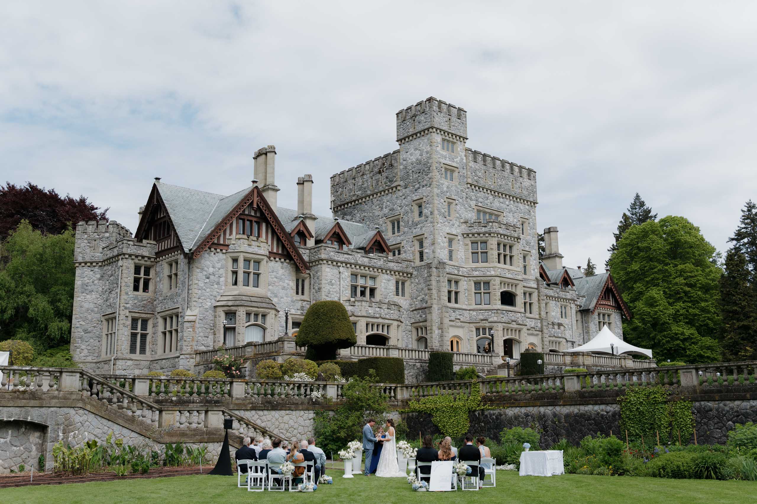 hatley castle wedding ceremony taking place on the grass with a castle background