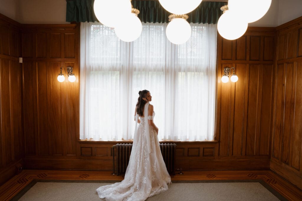 Hatley Castle Wedding in Victoria BC captured by local Wedding Photographer Hayley Zumkeller indoors while the bride was getting ready and putting on her scarf