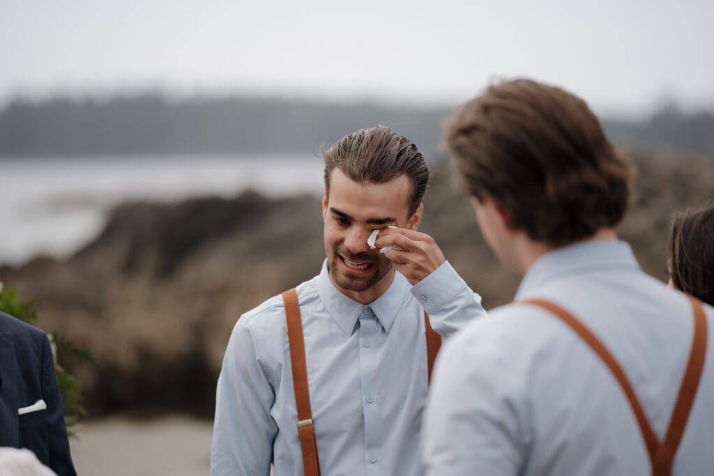 The son of the Groom sheds tears following his Dad's elopement ceremony at Crystal Cove Beach Resort at Chesterman Beach. Local Tofino BC Wedding Photographer captures moments on both photo and video.