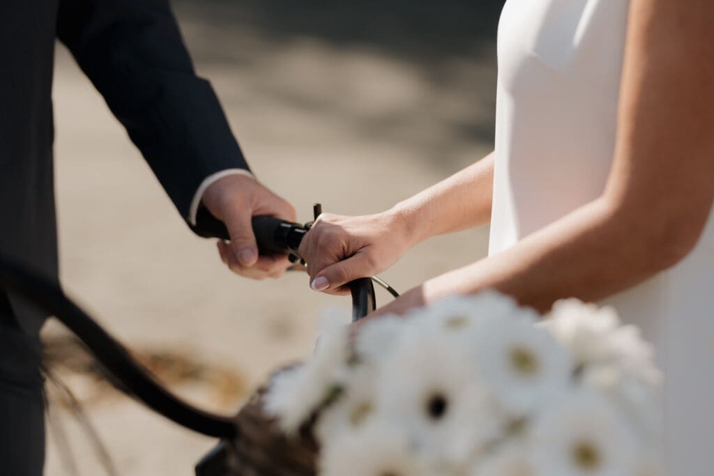 Tofino BC Wedding Photographer and Videographer captures bride and groom after their wedding ceremony at Crystal Cove Resort on Chesterman Beach. Couple rides bike on the beach.