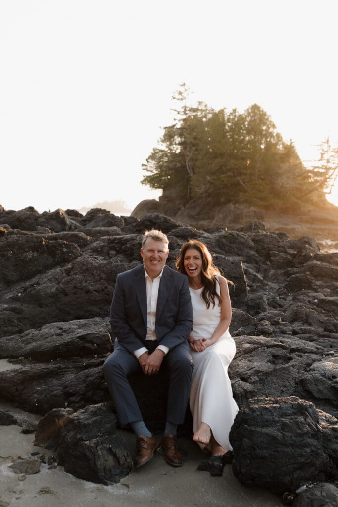 Hayley Zumkeller photography and videography team capture a newly married couple sitting on the rocks together beach side at Chesterman Beach in Tofino BC.