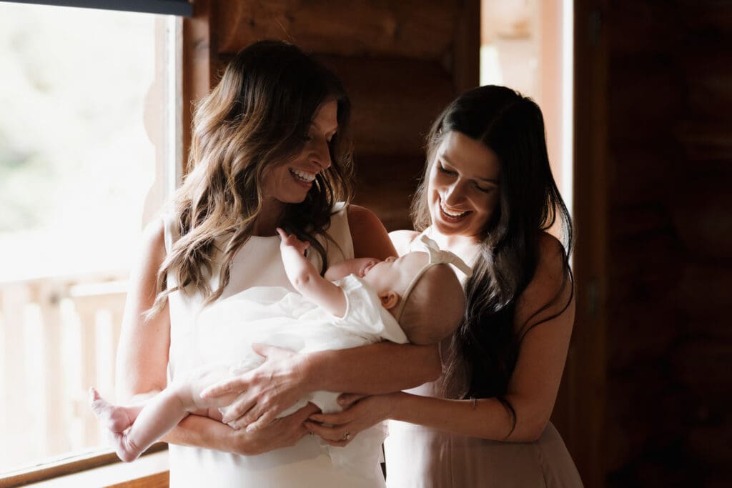 Hayley Zumkeller photography and videography team capture a bride getting ready in Crystal Cove Cabin for her Tofino BC Wedding. She takes a moment to pause with her baby granddaughter and daughter. Local Tofino BC Wedding Photographer captures moments on both photo and video.