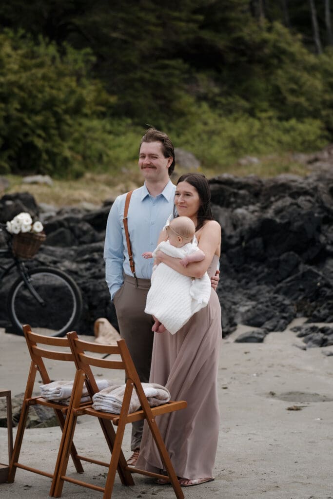 The son of the Groom with is wife and their daughter look on emotionally at their Dad following the elopement ceremony at Crystal Cove Beach Resort at Chesterman Beach. Local Tofino BC Wedding Photographer captures moments on both photo and video.