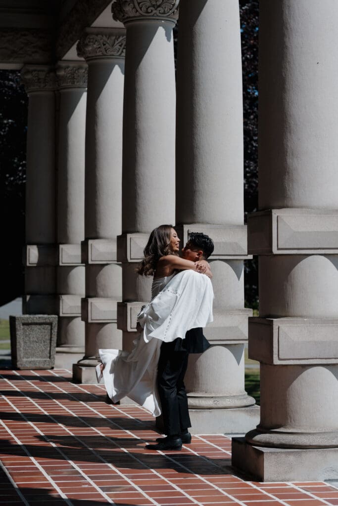 Hayley Zumkeller, Victoria BC Wedding Photographer and Videographer, captures a groom and bride hugging on the Parliament grounds on Vancouver Island.