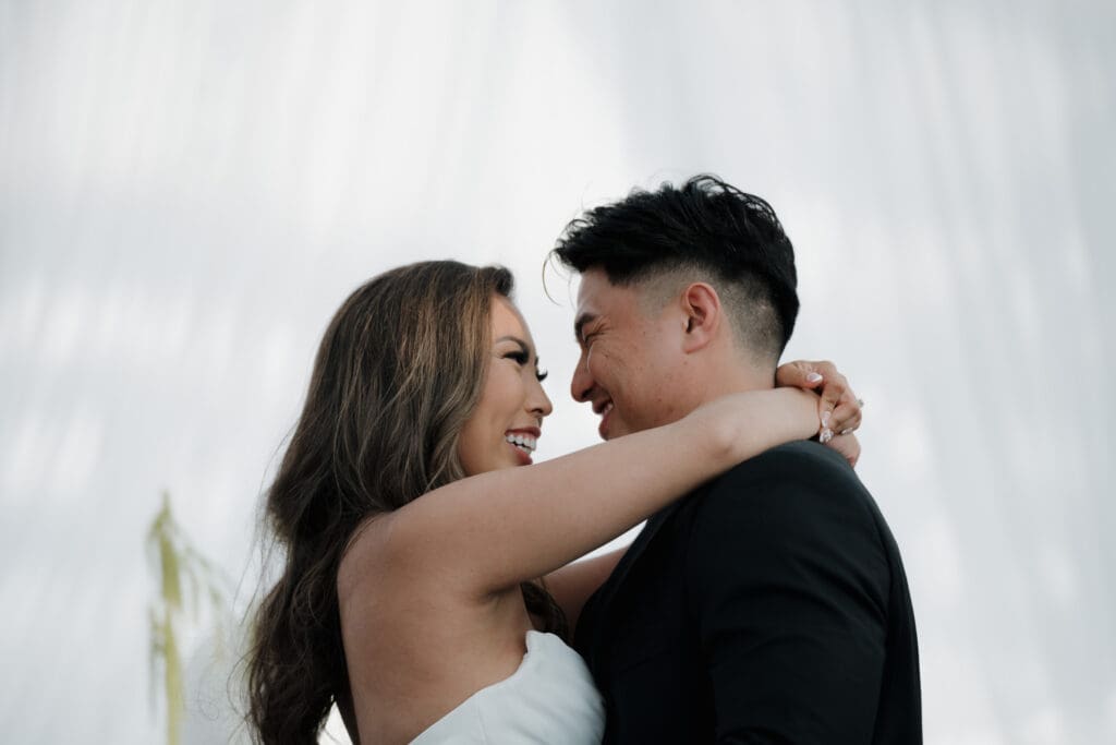 Hayley Zumkeller Photography and Videography team from Victoria BC capture a bride and groom embracing during their reception at Laurel Point Inn, looking deeply into each other's eyes.