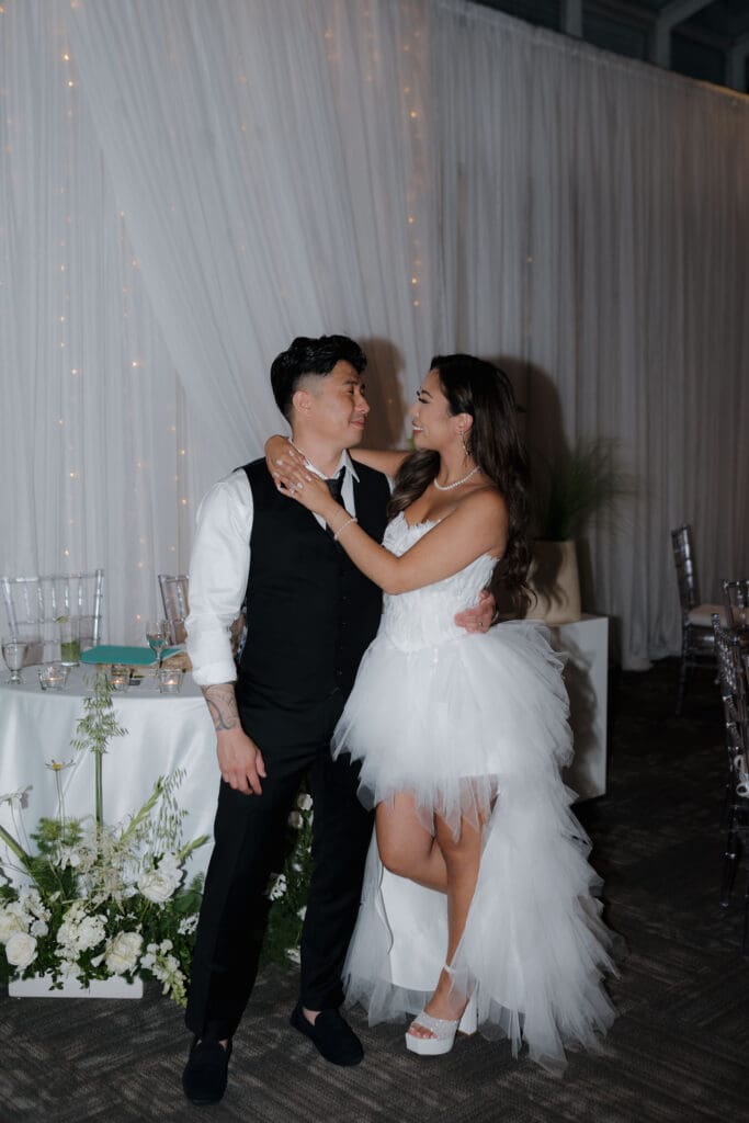 Hayley Zumkeller, Victoria BC Wedding Videographer and Photographer and team capture the bride and groom embrace after she has changed into her chic party dress for their reception at Laurel Point Inn on Vancouver Island.
