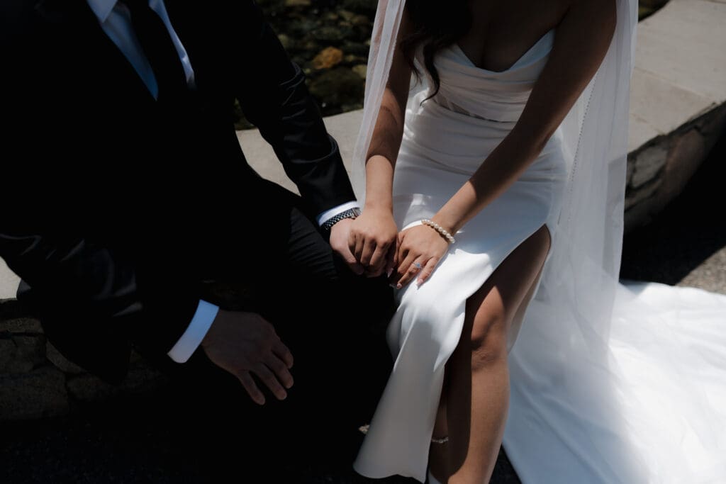 Hayley Zumkeller, Victoria BC Wedding Videography and Photography team capture close up shot of the wedding couple holding hands at Laurel Point Inn during a mini-destination on Vancouver Island.