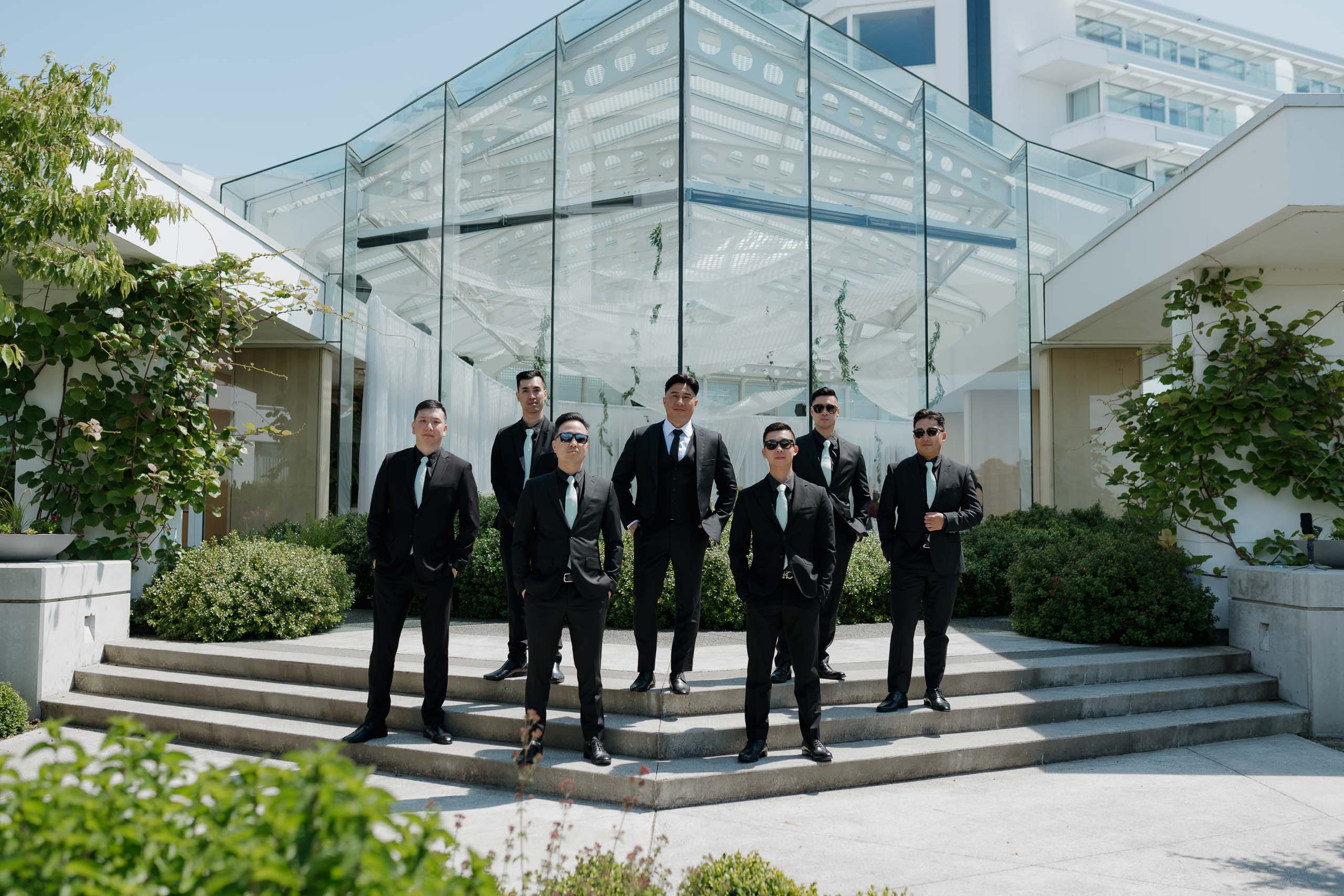 Hayley Zumkeller, Victoria BC Wedding Photographer and Videographer, captures the groom and groomsmen smiling at Laurel Point Inn during their Destination Wedding Vancouver Island