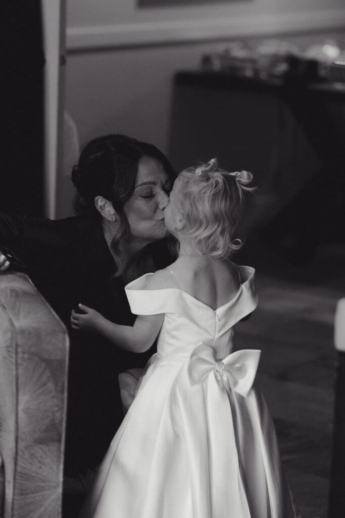 Hayley Zumkeller Photography & Videography team capture an elegant wedding on Vancouver Island. In this image the Mother of the Bride is kissing her granddaughter (the bride's daughter) in an emotional moment while getting ready.