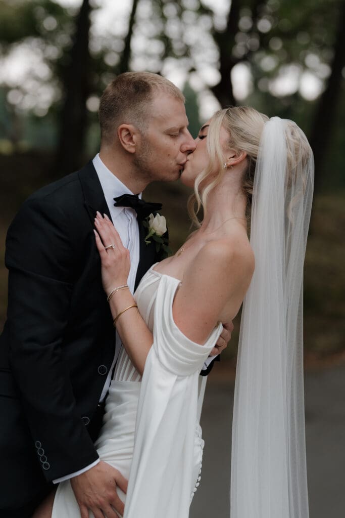 Hayley Zumkeller photography and videography team capture a bride and groom kissing at the waterfall at Olympic View golf course on Vancouver Island.