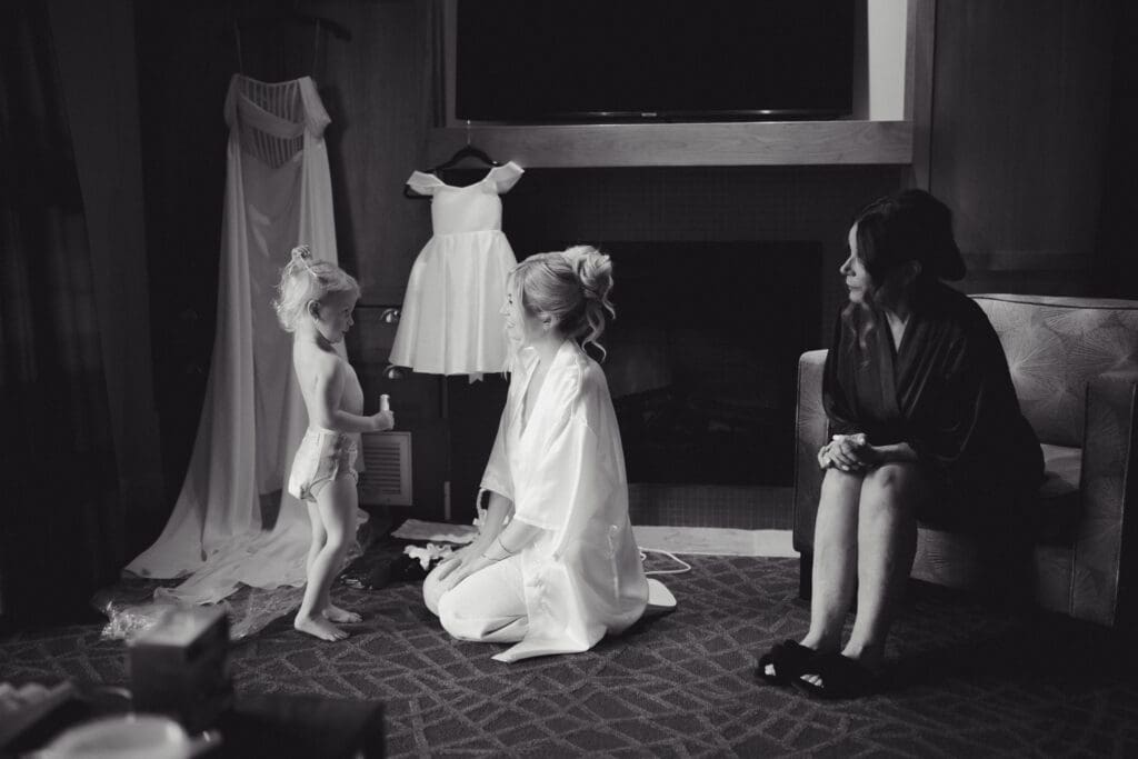 Hayley Zumkeller Photography & Videography team capture an elegant wedding on Vancouver Island. In this image the Mother of the Bride is watching her granddaughter (the bride's daughter) happily chatting while getting ready, along with the bride (her daughter) in an emotional moment while getting ready.