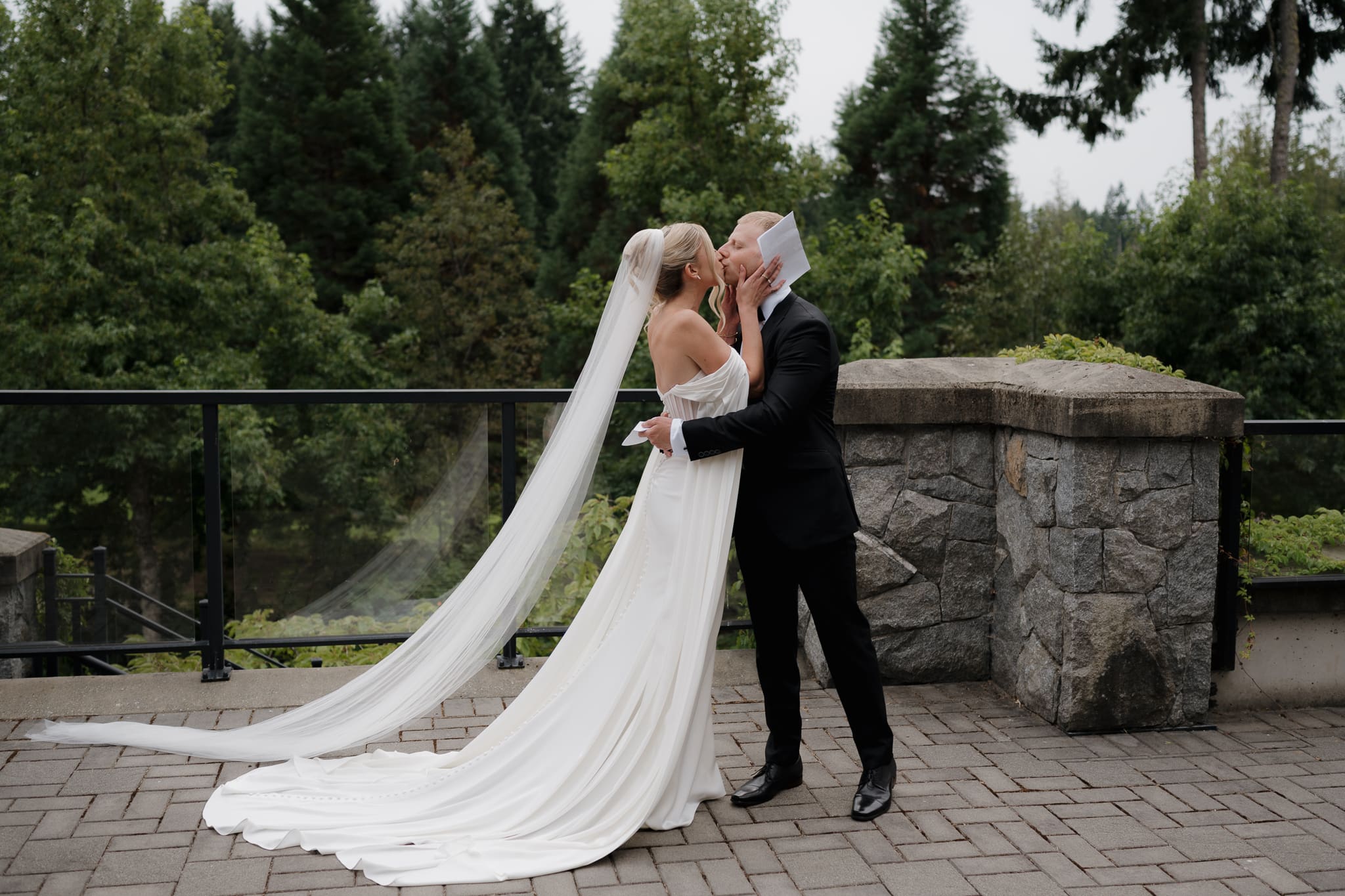 Hayley Zumkeller photography and videography team from Victoria BC capture the first look kiss between a bride and groom. Her elegant gown and flowing veil and gown caught in his romantic embrace.