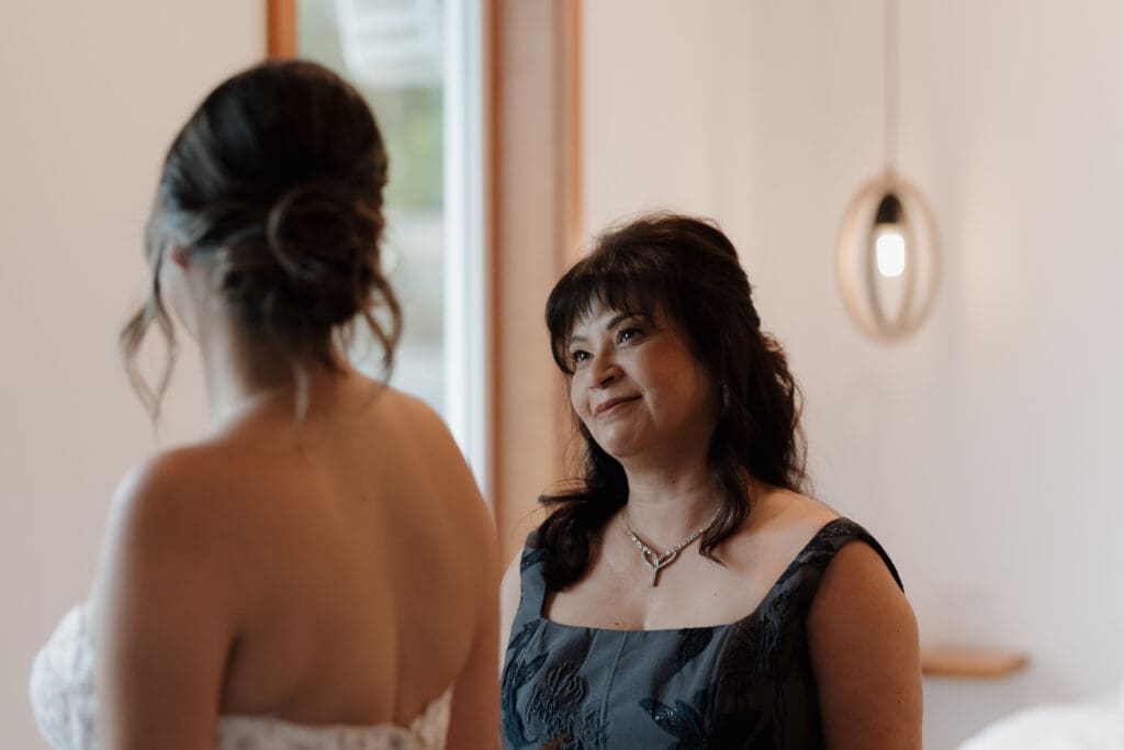 The Mother of the Bride is captured looking lovingly at her daughter that has just finished getting ready for her Gowlland Harbour Wedding on Vancouver Island. The moment is captured by Hayley Zumkeller photography and videography team from Victoria BC.