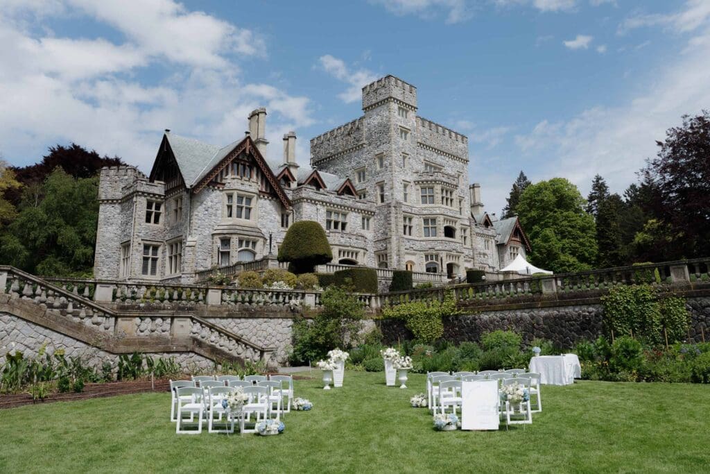 Hayley Zumkeller, Victoria BC Wedding Photographer and Videographer, captures the historical Hatley Castle as it sits behind a wedding ceremony set up on the expansive lawn.