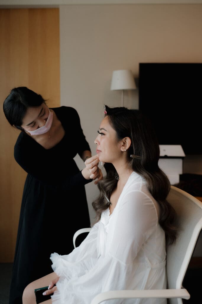 A bride has her make-up applied prior to her wedding ceremony at Inn at Laurel Point on Vancouver Island. Image captured by Victoria BC's Hayley Zumkeller photography and videography team.