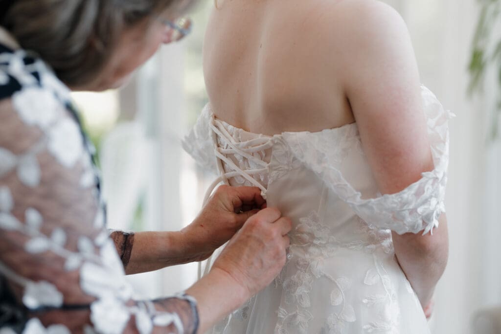 This image of the back of an elegant wedding dress captured by Hayley Zumkeller photography and videography team showcases the intricate designs that can be available to brides on Vancouver Island.