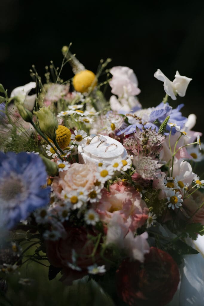 Hayley Zumkeller photography and videography team from Victoria BC capture the stunning floral arrangement surrounding the wedding rings for this Vancouver Island Wedding.