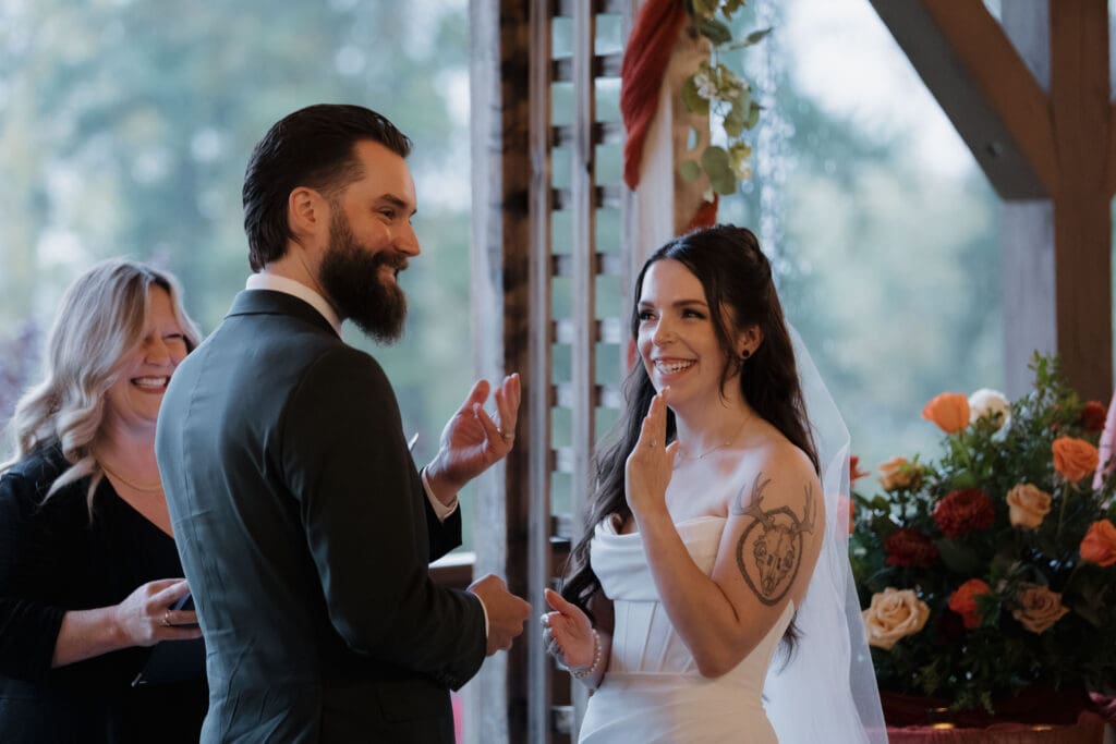 Hayley Zumkeller photography and videography team from Victoria BC a bride and groom as they show off their new rings during their wedding ceremony at Church and State Winery on Vancouver Island.