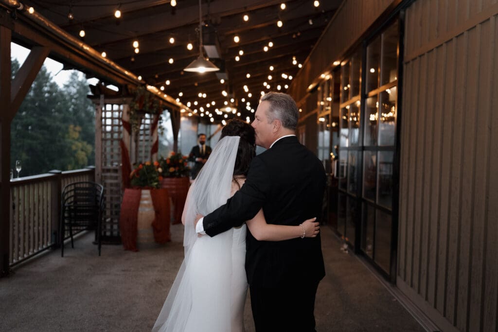 The father of the bride embraces his daughter following this Church and State Winery wedding ceremony. Image captured by Hayley Zumkeller photography and videography team from Victoria BC.