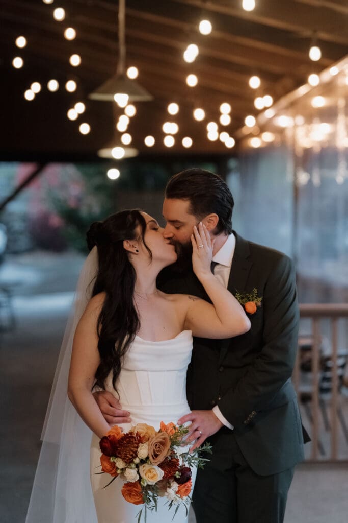 Hayley Zumkeller photography and videography team from Victoria BC capture a kiss between a newly married bride and groom following their wedding ceremony at Church and State Winery on Vancouver Island.