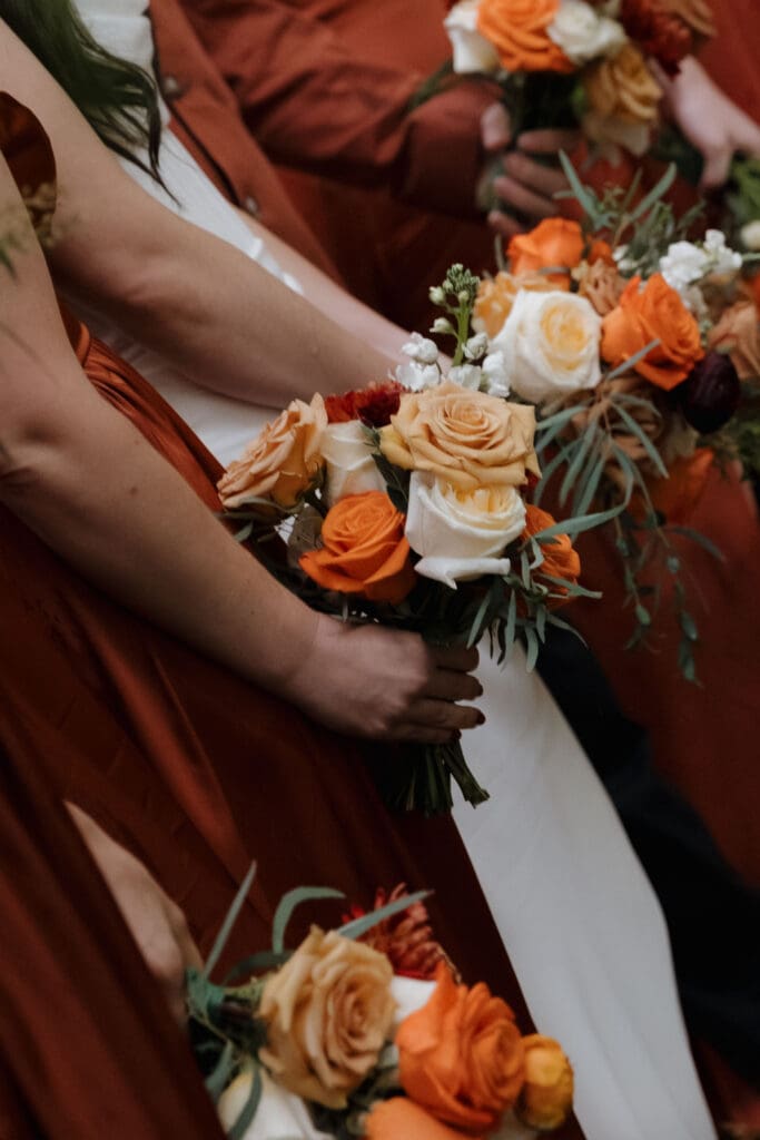 Hayley Zumkeller photography and videography team from Victoria BC captures the bridal and bridesmaid bouquets, filled with deep fall colours, in the forest of this Church and State Winery wedding on Vancouver Island.