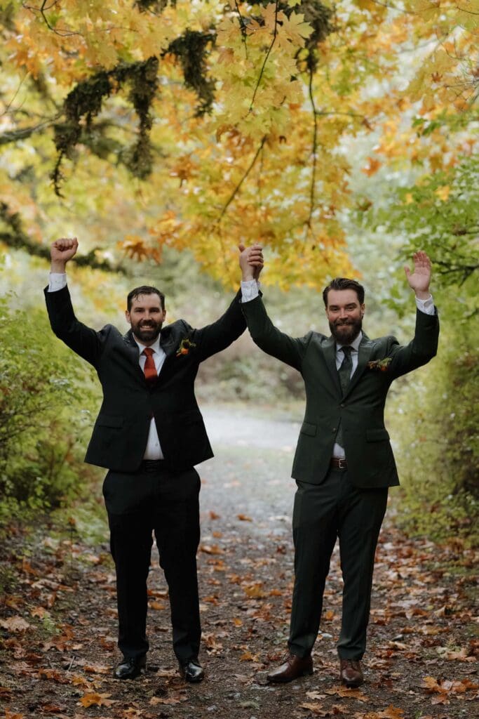 Hayley Zumkeller photography and videography team from Victoria BC captures a groom with one of his groomsman celebrating in the forest at Church and State Winery on Vancouver Island.