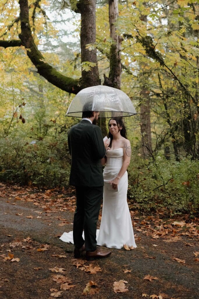 Couple sharing private vows in Vancouver Island forest in the rain surrounded by fall colours