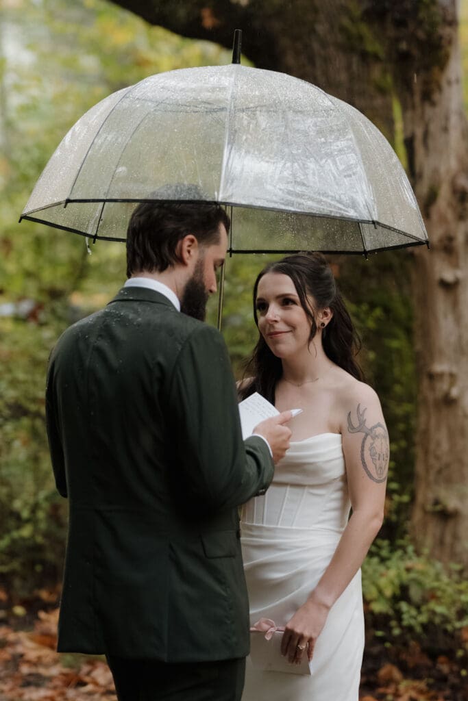 Couple sharing private vows in Vancouver Island forest in the rain surrounded by fall colours