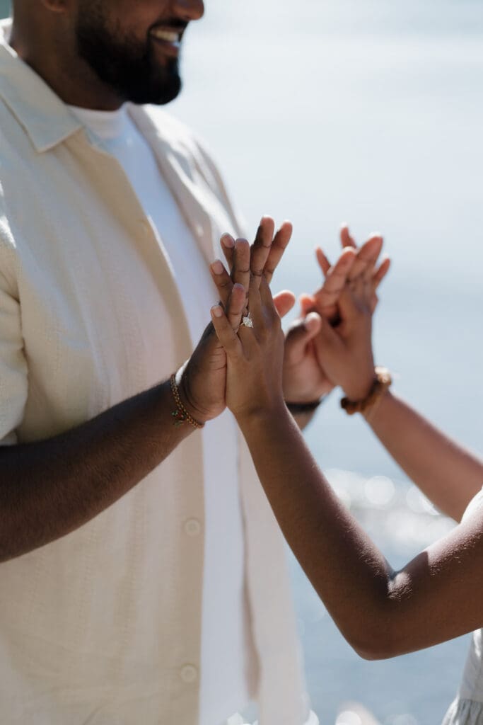 what to wear to your engagement photoshoot, photo of a couple holding hands showing off the new engagement ring