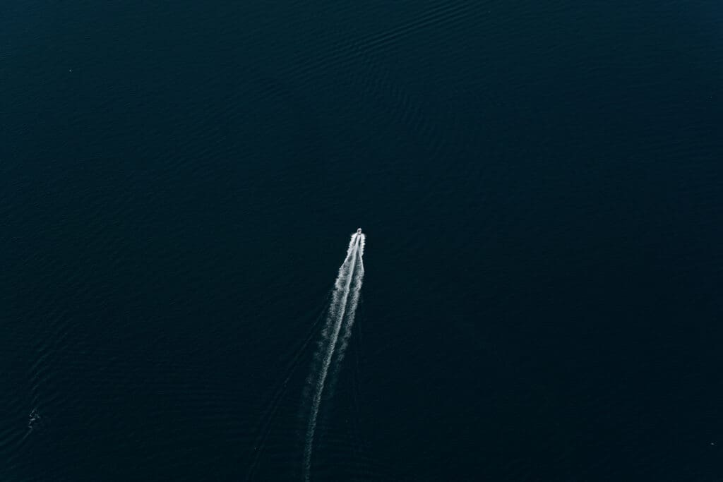 Capturing boats below from a helicopter flying over mountains during Vancouver Island helicopter elopement in British Columbia.