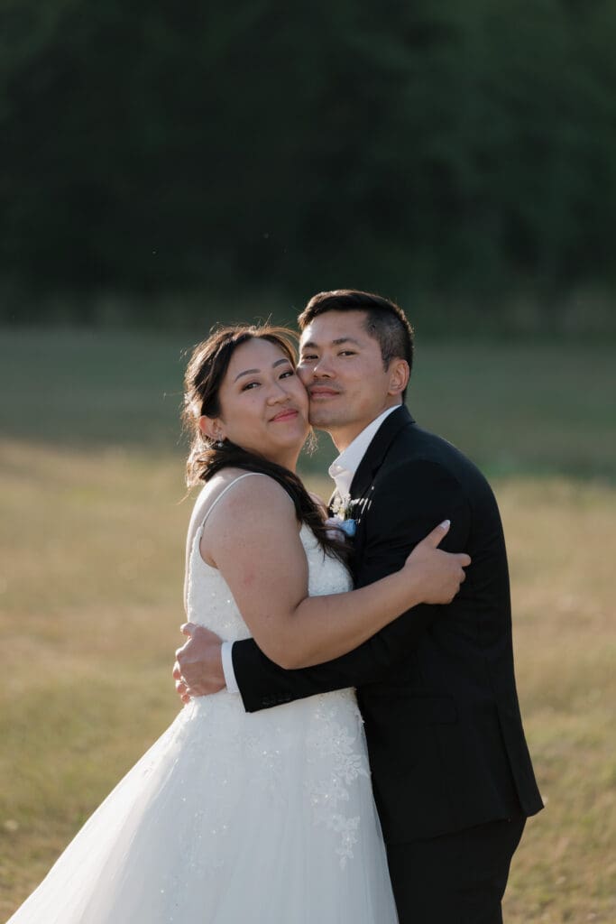 Romantic close-up of couple laughing and embracing following their helicopter elopement during golden hour on Vancouver Island. Image captured by Hayley Zumkeller photography and videography team from Victoria BC.