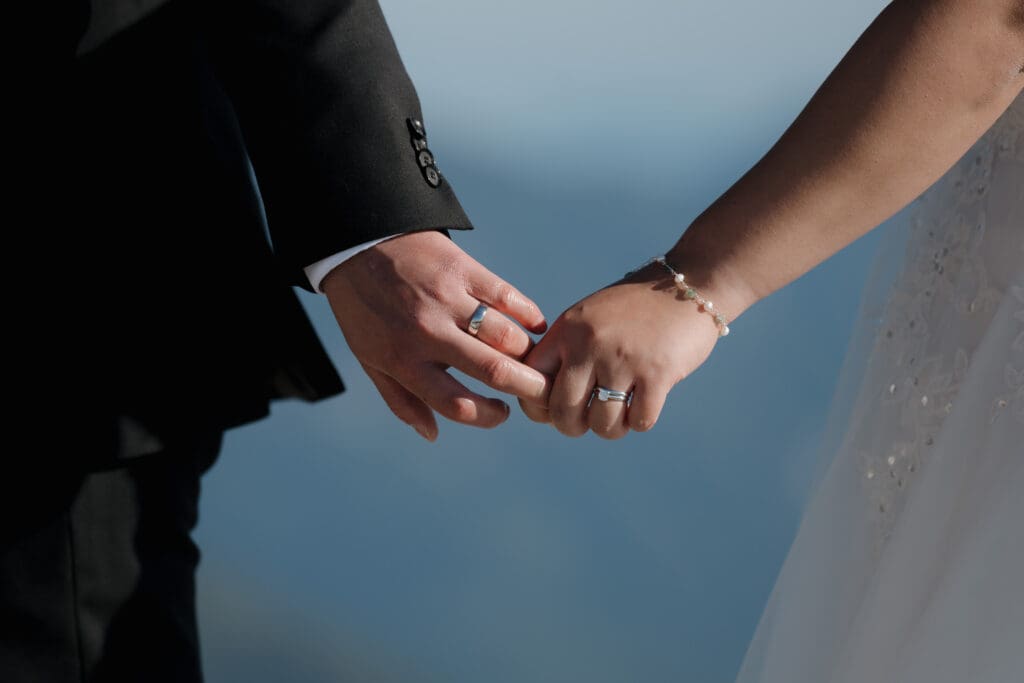 The clasped hands of a newly bride and groom during their helicopter elopement on Vancouver Island. 