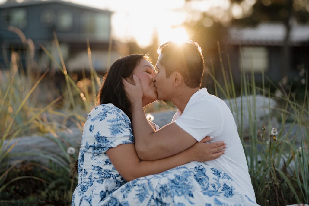 Golden hour engagement session at Saratoga Beach with couple sitting together in warm sunset light Vancouver Island.