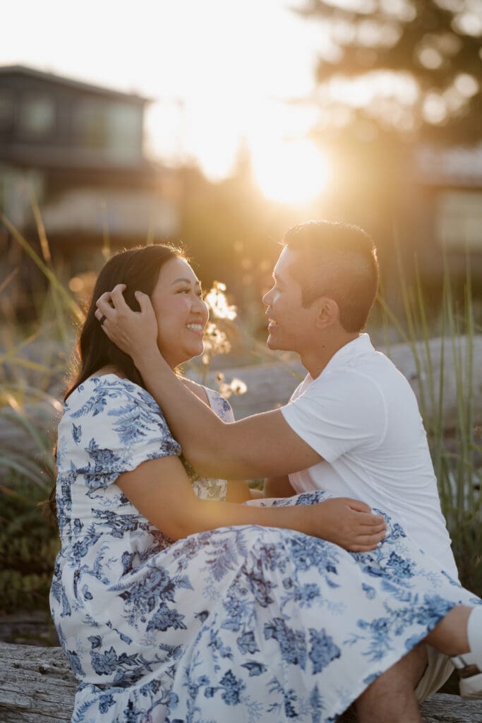 Golden hour engagement session at Saratoga Beach with couple sitting together in warm sunset light Vancouver Island.