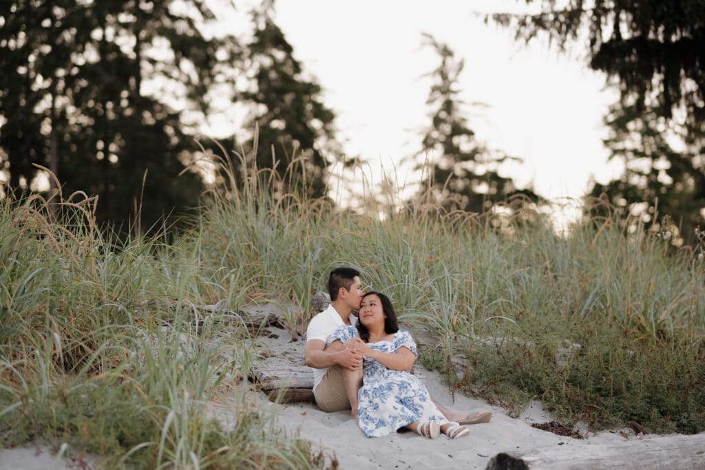 Romantic close-up of couple embracing near the tall grass during Saratoga Beach engagement photos at sunset on Vancouver Island.