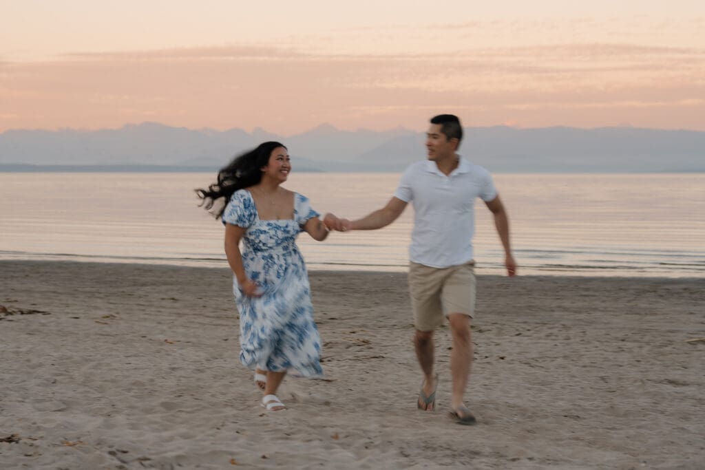 An engaged couple laugh and enjoy each other during their Saratoga Beach engagement photos on Vancouver Island with the beautiful August golden hour sunset in the background.