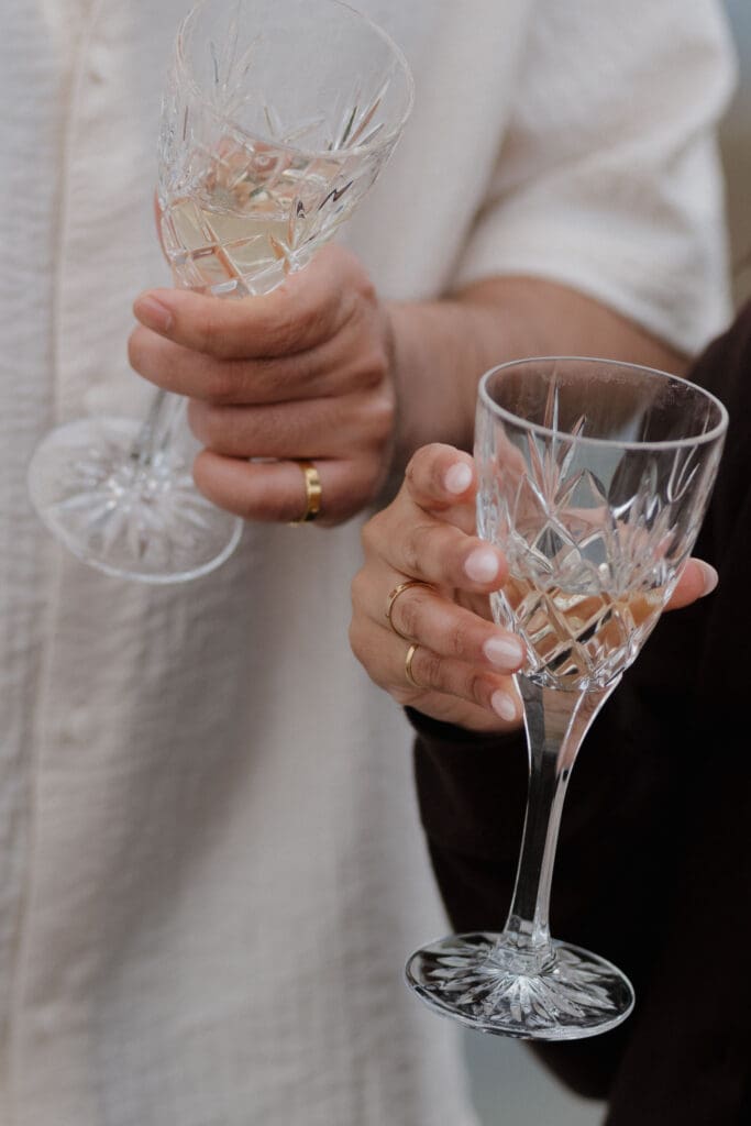 Newly engaged couple celebrating with champagne at Saxe Point Park, Victoria BC — proposal and engagement photography by Hayley Zumkeller