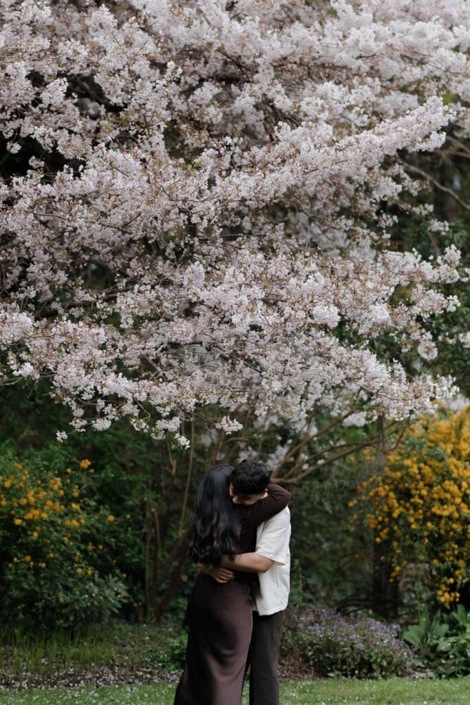 Candid emotional moment between Harwinder and Imran during surprise proposal shoot at Saxe Point Park, Victoria BC