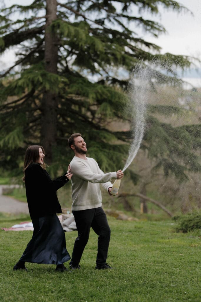 Victoria bc surprise proposal photographer captures champagne toast after a proposal in the government house gardens in victoria bc
