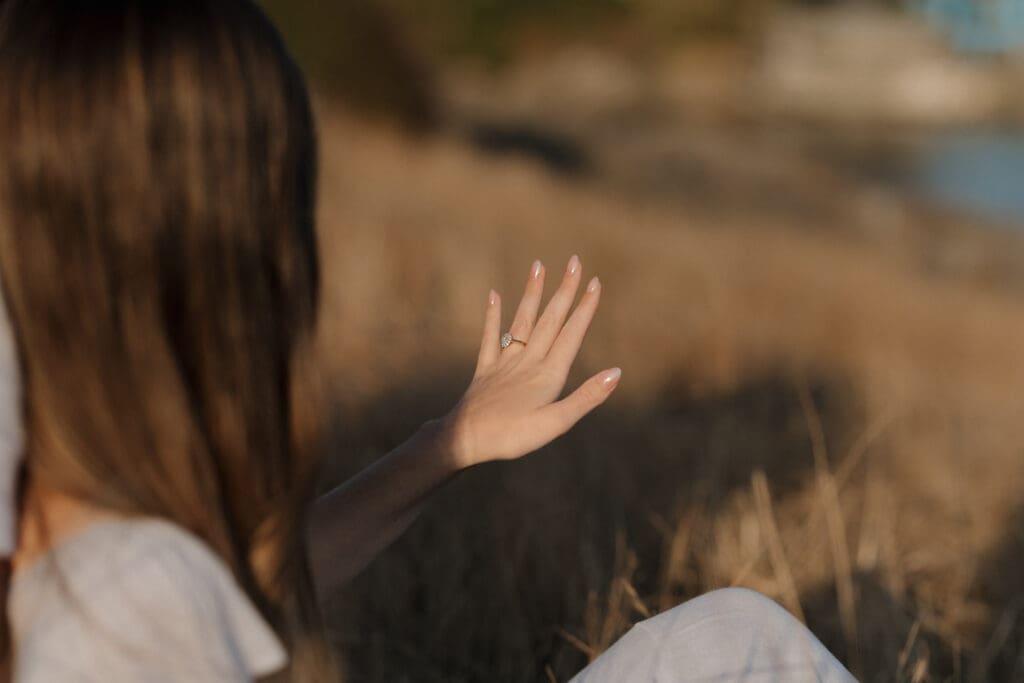 Close up of engagement ring during surprise proposal at Saxe Point Park in Victoria BC photographed by a Vancouver Island proposal photographer