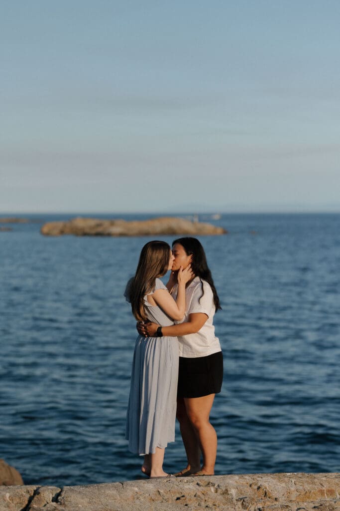 Romantic engagement portraits overlooking the ocean at Saxe Point Park in Victoria BC with warm sunset light and Vancouver Island coastal views