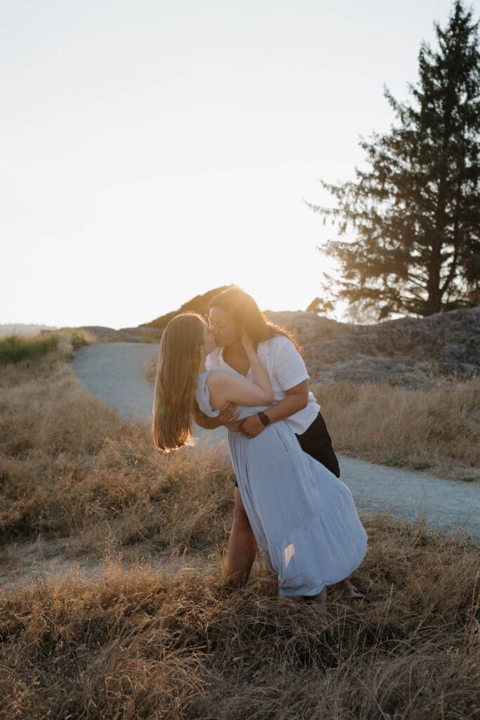 Sunset engagement photos on the rocks after a surprise proposal at Saxe Point Park in Victoria BC with ocean views and golden evening light