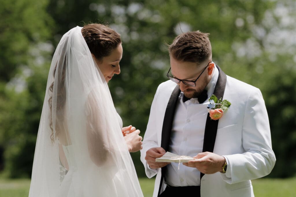 A bride shares the love letters she wrote to her groom consistently over the years of their relationship during their first look at Wildflower on Watts.