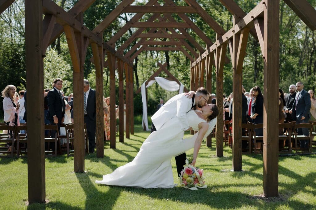 A newly married husband dips his wife for their exit kiss at Wildflower on Watts in Honesdale PA