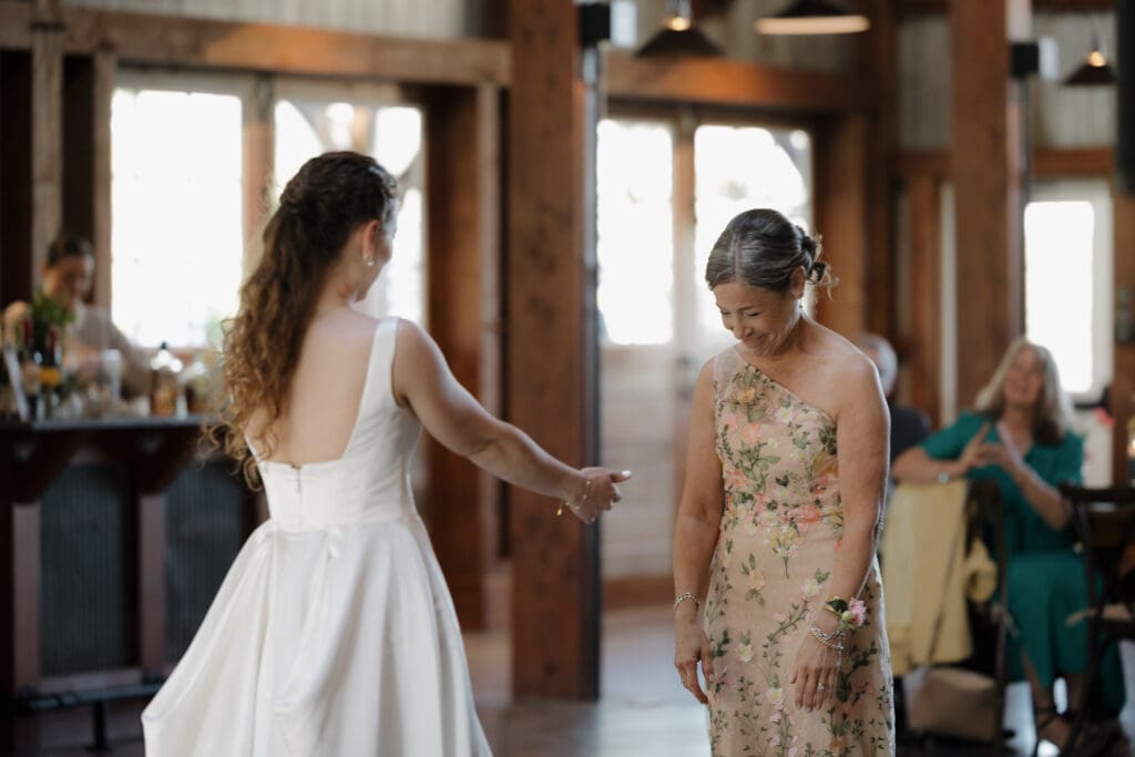 A bride surprises her mom with a special Mother/Daughter dance during the wedding reception. Captured by travel wedding photographer Hayley Zumkeller from Victoria BC.