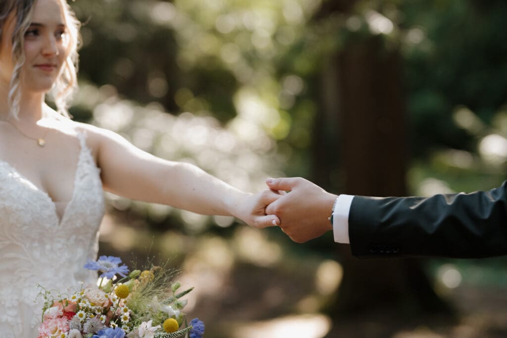 The clasped hands of a newly married bridge and groom following their wedding ceremony in Nanaimo BC. This small but meaningful moment was captured by Hayley Zumkeller's Vancouver Island Wedding Videography team.