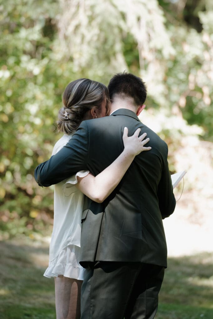 A bride and groom share a loving hug during their first look as they exchange private vows in Nanaimo BC. Captured by Hayley Zumkeller's Vancouver Island Wedding Videography team.