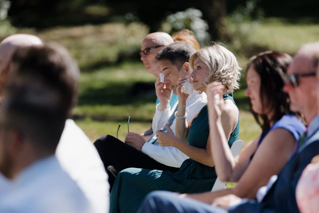 Family members wipe away tears at this intimate and meaningful outdoor ceremony on a family property in Nanaimo BC. Captured by Hayley Zumkeller's Vancouver Island Wedding Videography team.