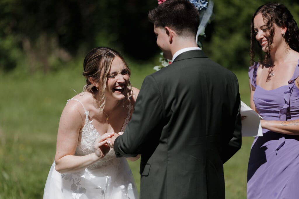 A bride laughs during her outdoor wedding ceremony in Nanaimo BC. This moment of joy captured by Hayley Zumkeller's Vancouver Island Wedding Videography team from Victoria BC.
